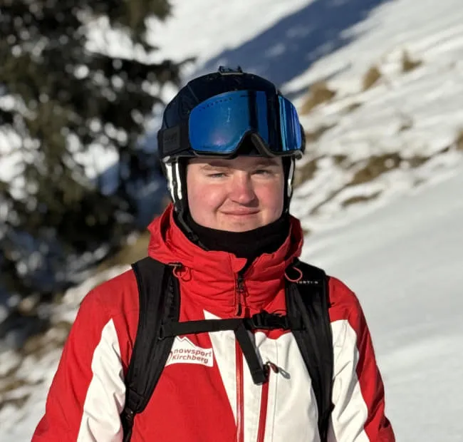 Skiender Lennard in rot-weißer Jacke auf Schnee