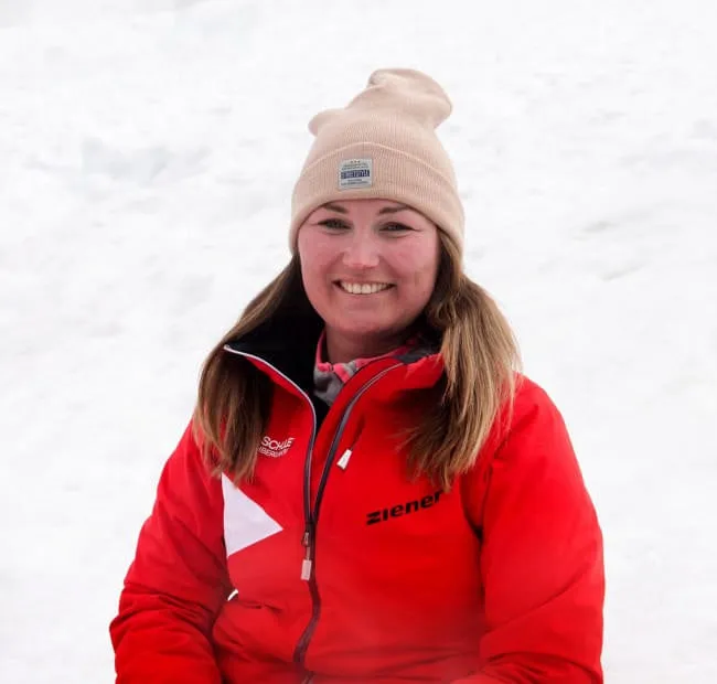 Frau in roter Jacke vor schneebedecktem Hintergrund
