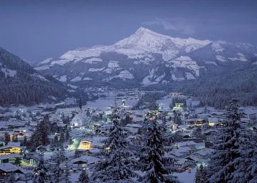 Schneebedecktes Dorf mit Bergen im Hintergrund
