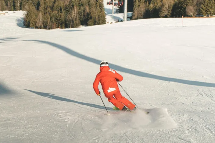 Skifahrer in roter Kleidung auf der Piste in Kirchberg