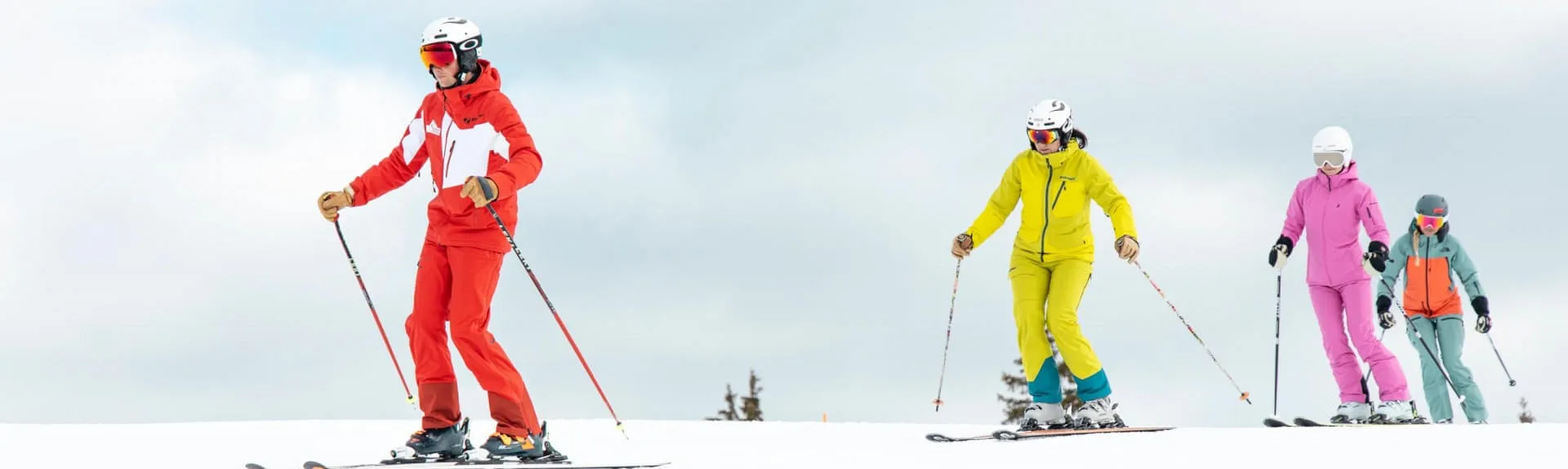 Skifahrer in bunten Outfits auf der Piste in Kirchberg